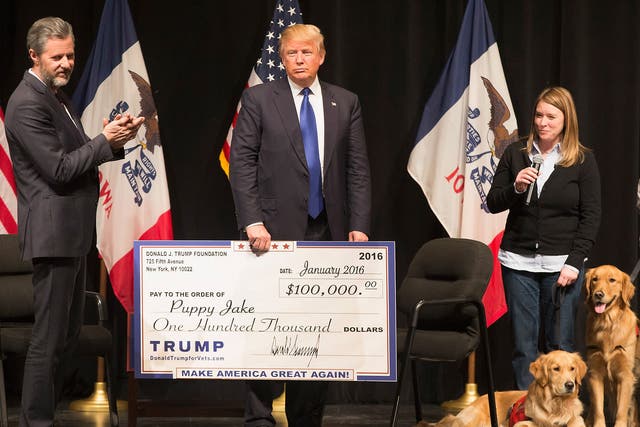 Donald Trump presenting a cheque for $100,000 to a charity that provides dogs for wounded veterans. He gave over $250,000 for the renovation of a fountain outside his Plaza Hotel.