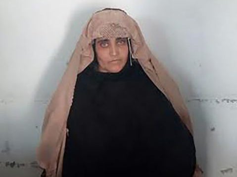 Afghan Sharbat Gula, the 'Afghan Girl' who appeared on the cover of a 1985 edition of National Geographic magazine, waits ahead of a court hearing in Peshawar