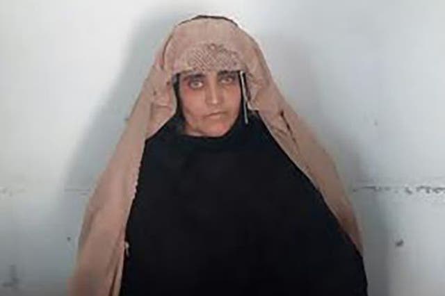 Afghan Sharbat Gula, the 'Afghan Girl' who appeared on the cover of a 1985 edition of National Geographic magazine, waits ahead of a court hearing in  Peshawar