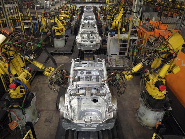 Robotic arms assemble and weld the body shell of a car on the production line of a different plant in Sunderland, UK