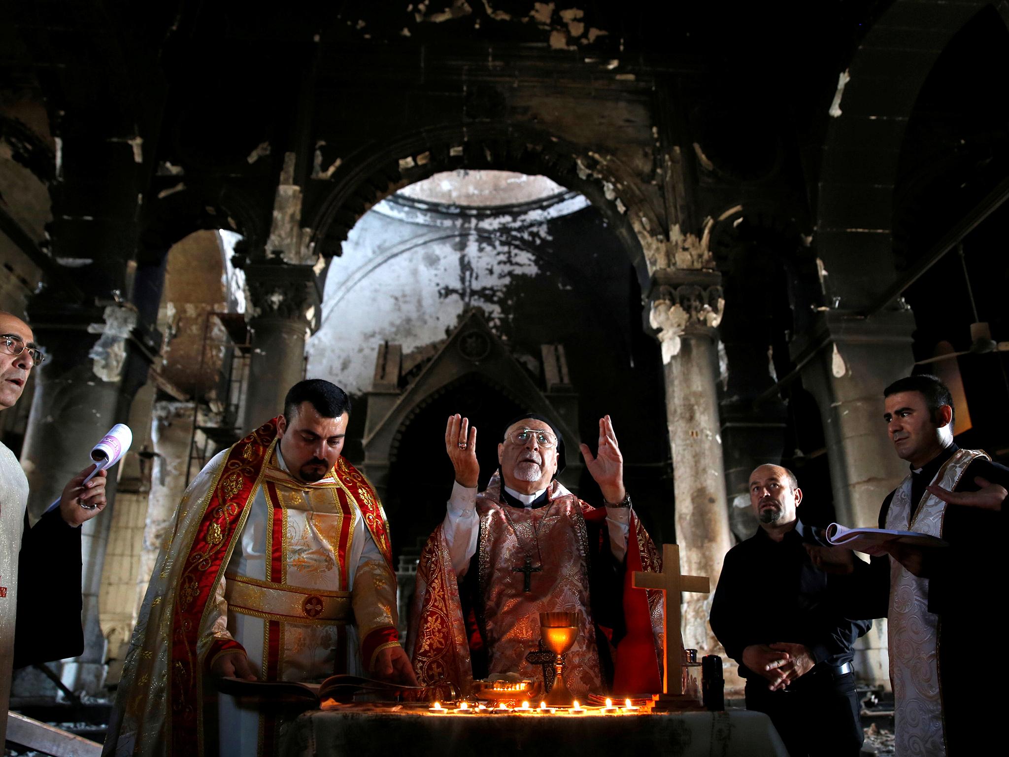 Iraqi priests hold Sunday mass at a church in Qaraqosh last month, after the town was recaptured from Isis