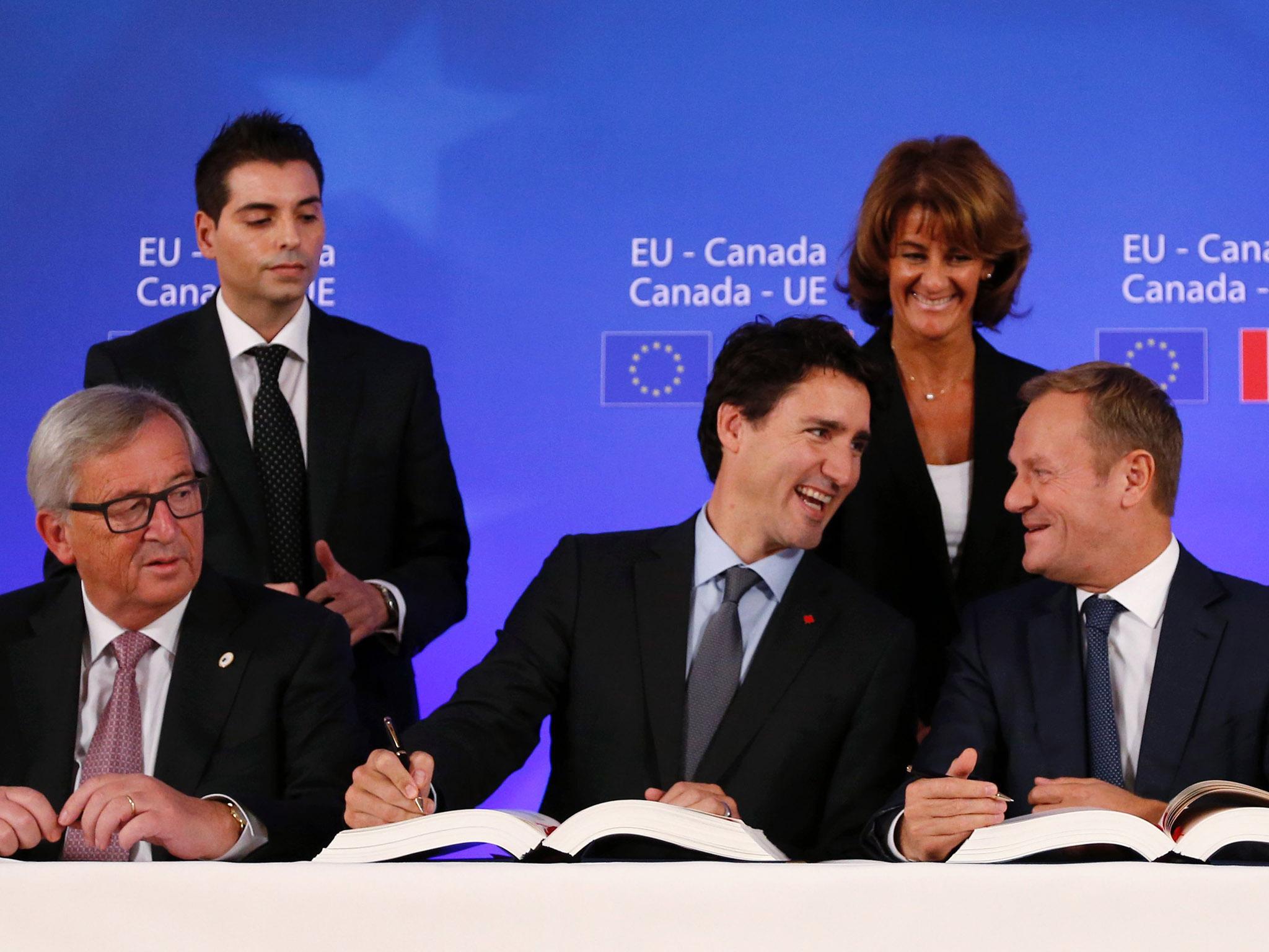 Jean-Claude Juncker (left), Justin Trudeau and Donald Tusk sign the Ceta deal in Brussels on Sunday