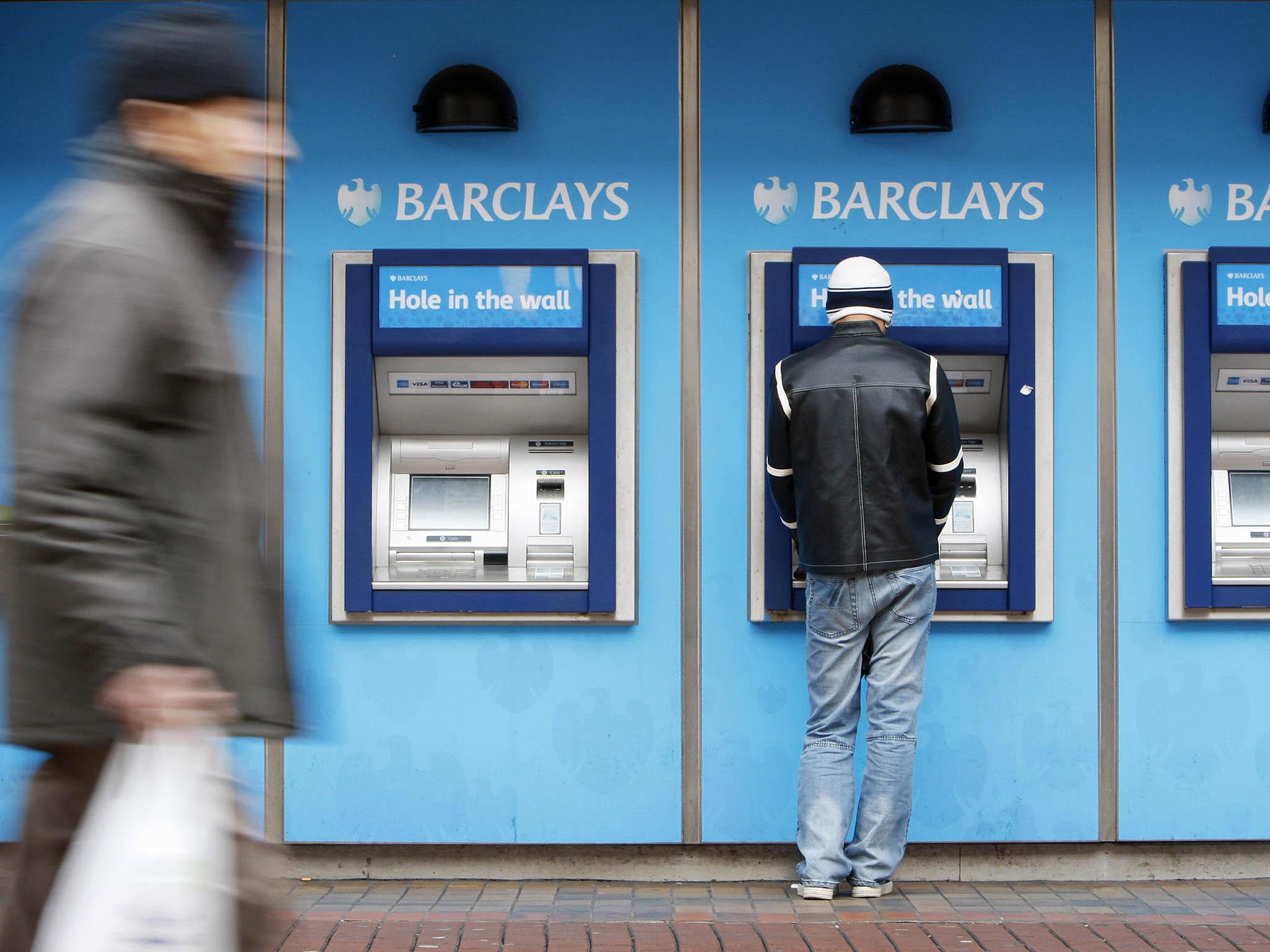 A man uses a cashpoint machine at a Barclays Bank branch in Hounslow, west London