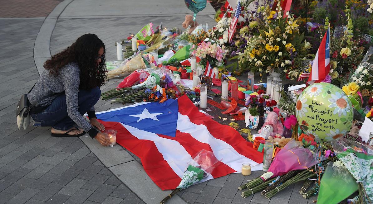 Jennifer Rivera pays her respects as she stops by a memorial setup near the Pulse gay nightclub where Omar Mateen killed 49 people on June 15, 2016 in Orlando, Florida.