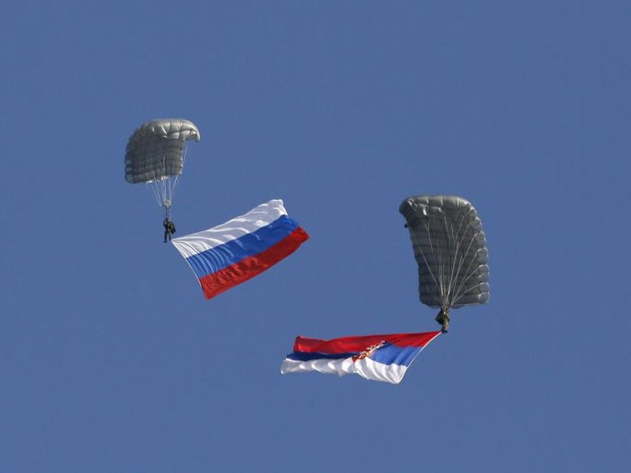 Serbian soldiers parachute from a Mil Mi-8 transport helicopter with a Russian, left, and Serbian flags during the Russian-Serbian joint anti terrorist exercise Srem 2014, at Nikinci training ground, 60 kilometers west of Belgrade, Serbia 14 November, 2014