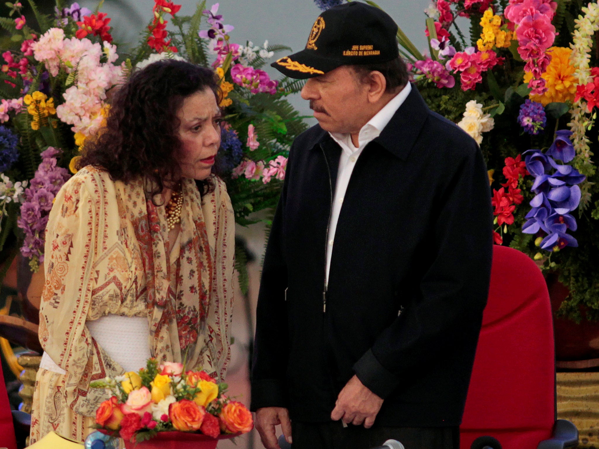Nicaragua's President Daniel Ortega speaks with his wife Rosario Murillo during a commemoration of the 37th anniversary of the founding of the army in Managua