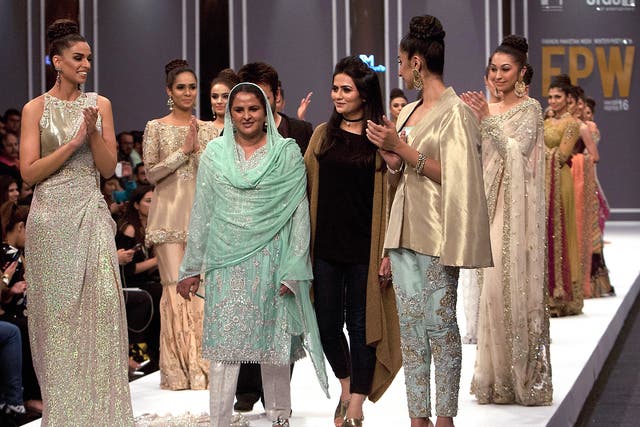 Pakistan's gang rape victim Mukhtar Mai, walks with models during a fashion show in Karachi, Pakistan