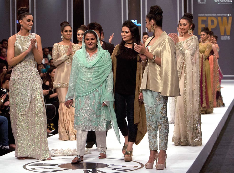 Pakistan's gang rape victim Mukhtar Mai, walks with models during a fashion show in Karachi, Pakistan