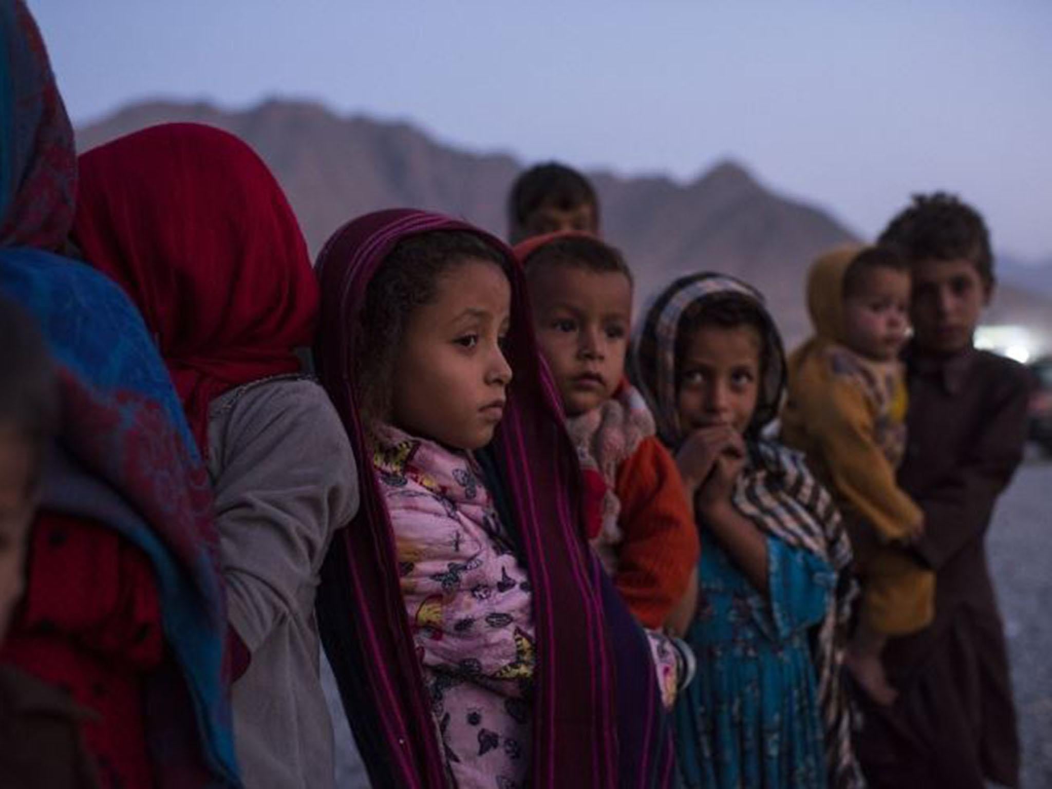 Afghan children arrive outside a UN centre on the outskirts of Kabul