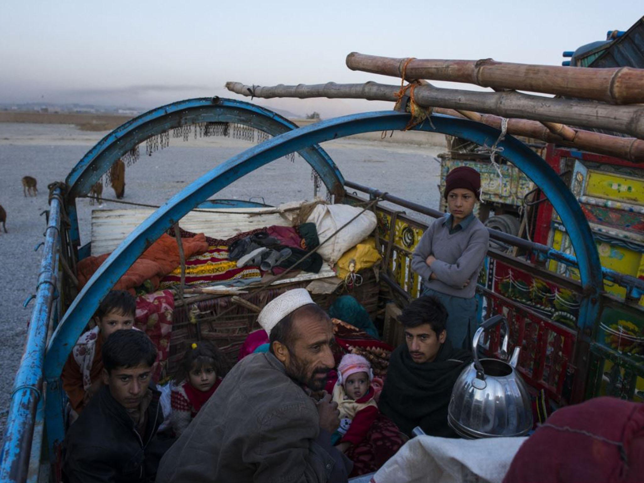 After driving from Pakistan the previous day to a UN ‘encashment’ centre on the outskirts of Kabul, a family of Afghans wake up at dawn and boil tea after a night sleeping on top of the trucks that carried them (Washington Post)