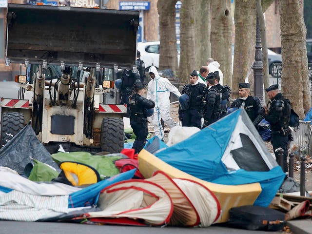 French police look on as a makeshift camp is dismantled near Stalingrad metro in the north of Paris