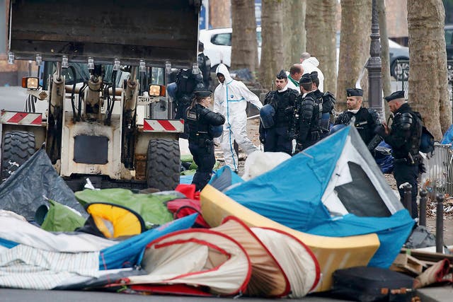French police look on as a makeshift camp is dismantled near Stalingrad metro in the north of Paris