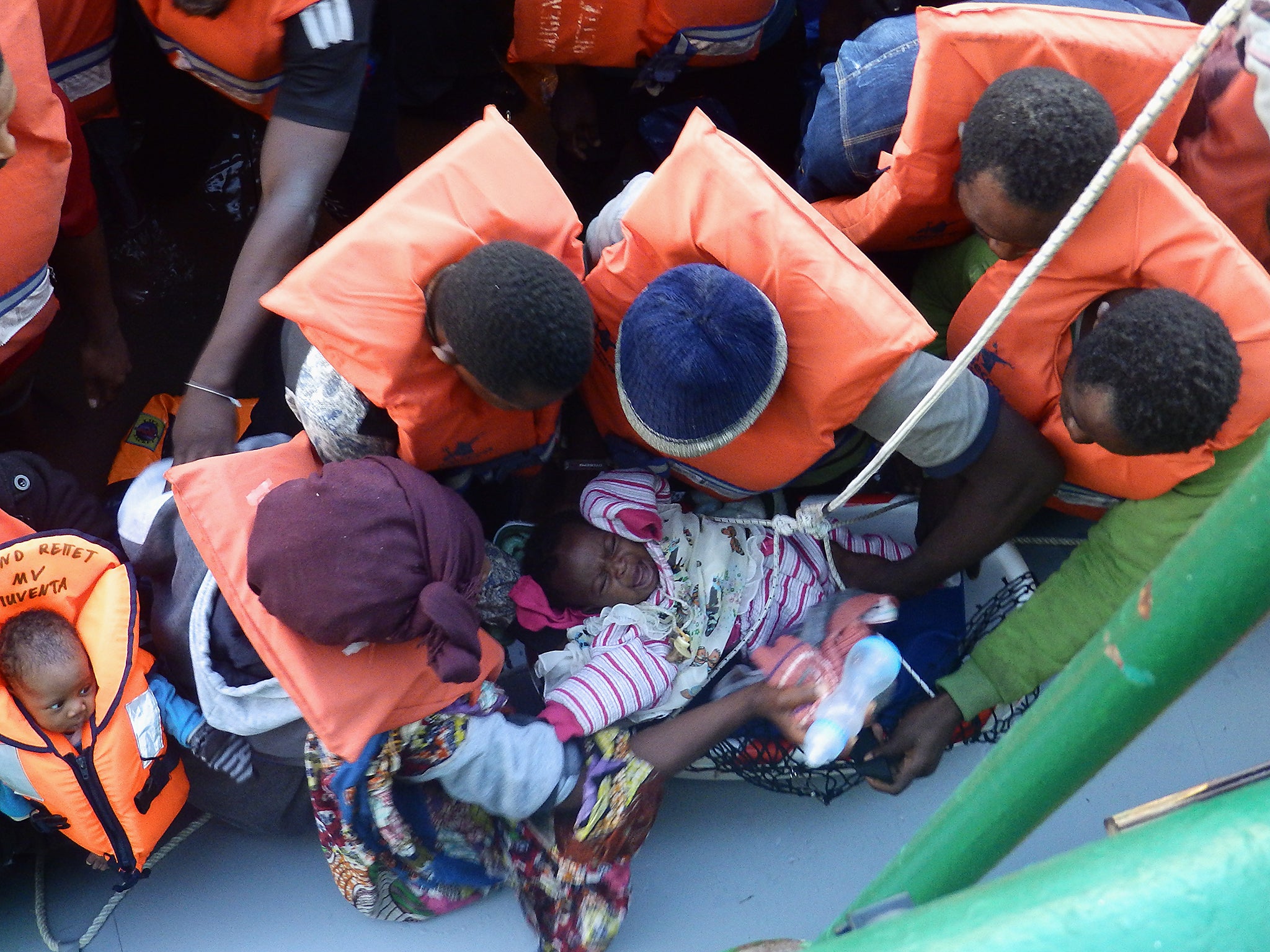 A baby being taken on to MSF's Bourbon Argos ship from a boat carrying 130 migrants and refugees