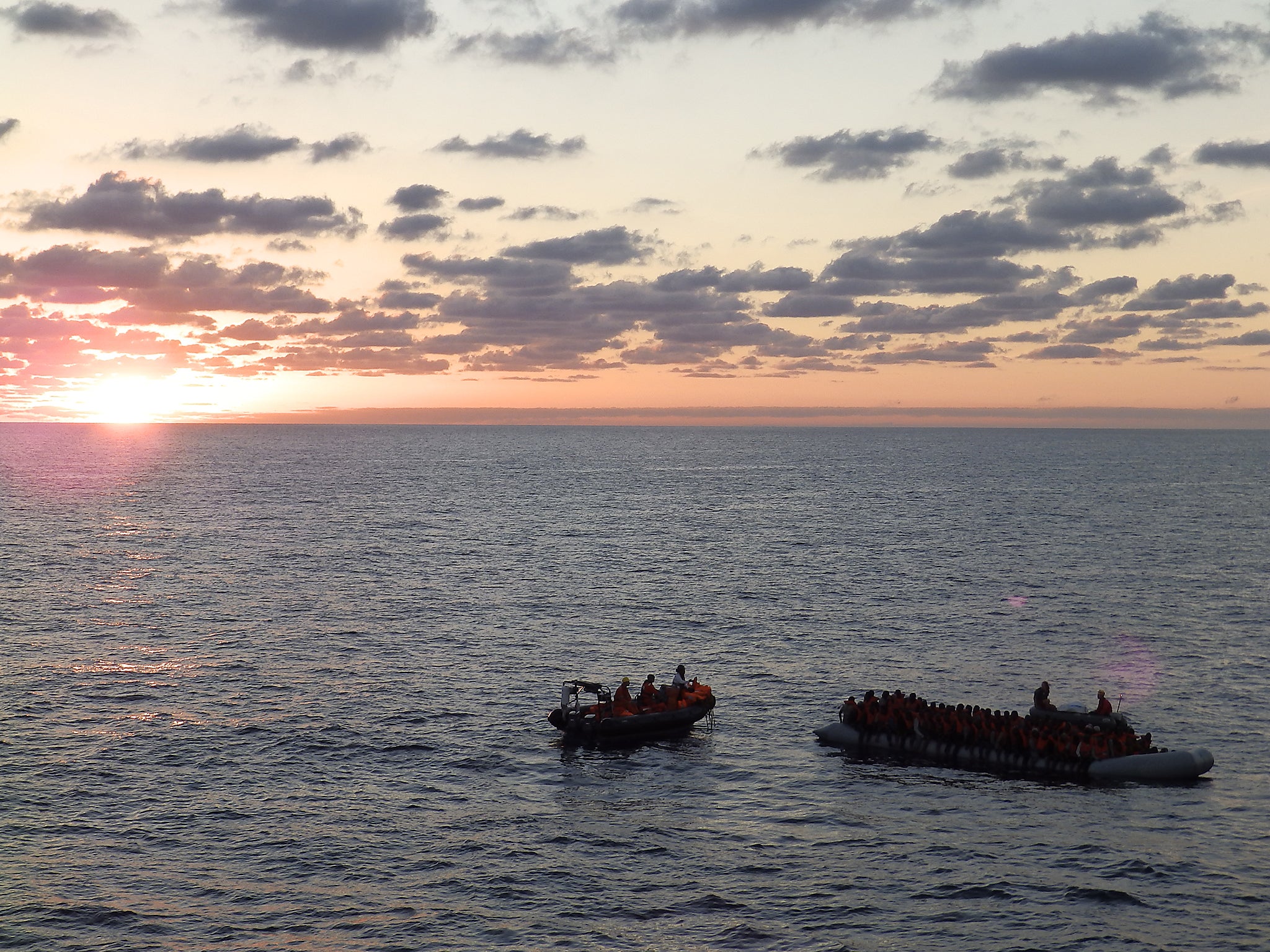 A crew from MSF's Bourbon Argos ship rescuing a boat carrying 130 migrants and refugees off the coast of Libya, at sunrise