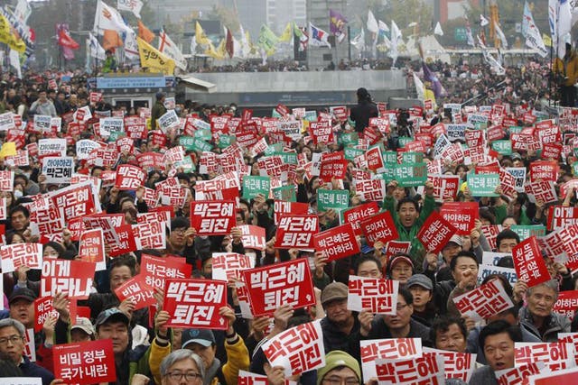 South Koreans hold signs reading ‘Park Geun-hye should step down’