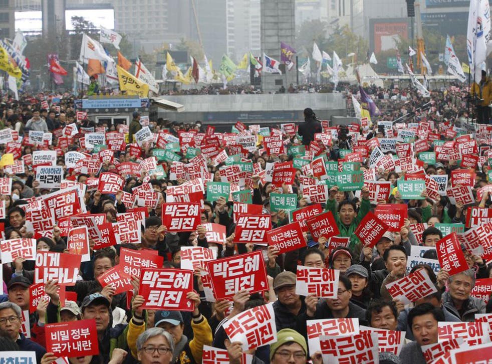 South Koreans hold signs reading ‘Park Geun-hye should step down’