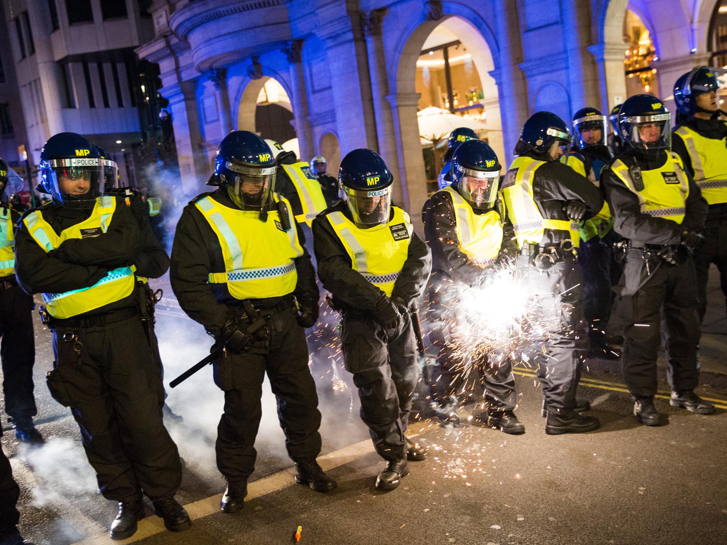 A firework is fired at a line of police by protesters during the Million Mask March (Getty Images )