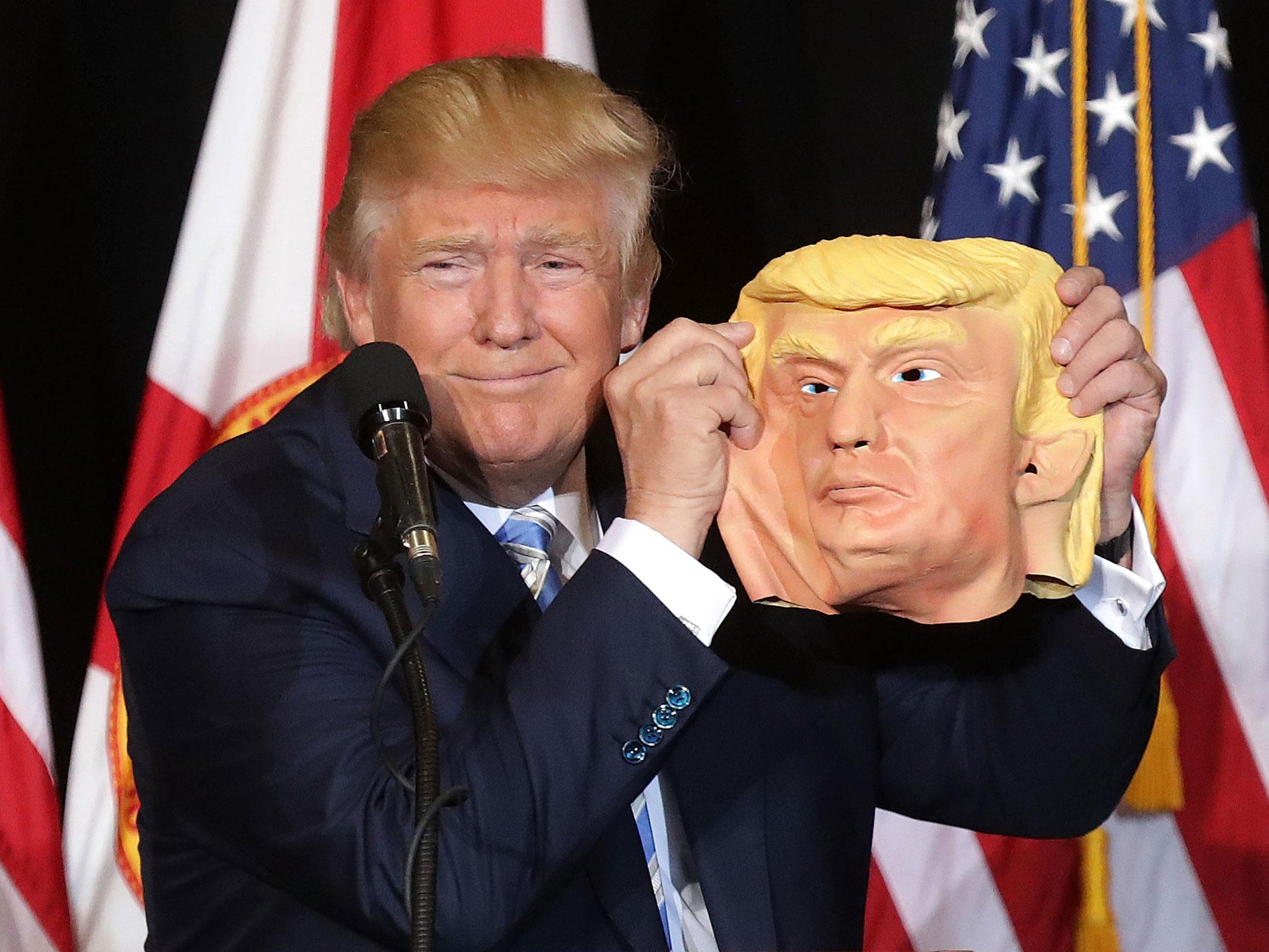 Donald Trump posing with a mask of his face tossed on stage by a supporter in Florida Chip Somodevilla/Getty