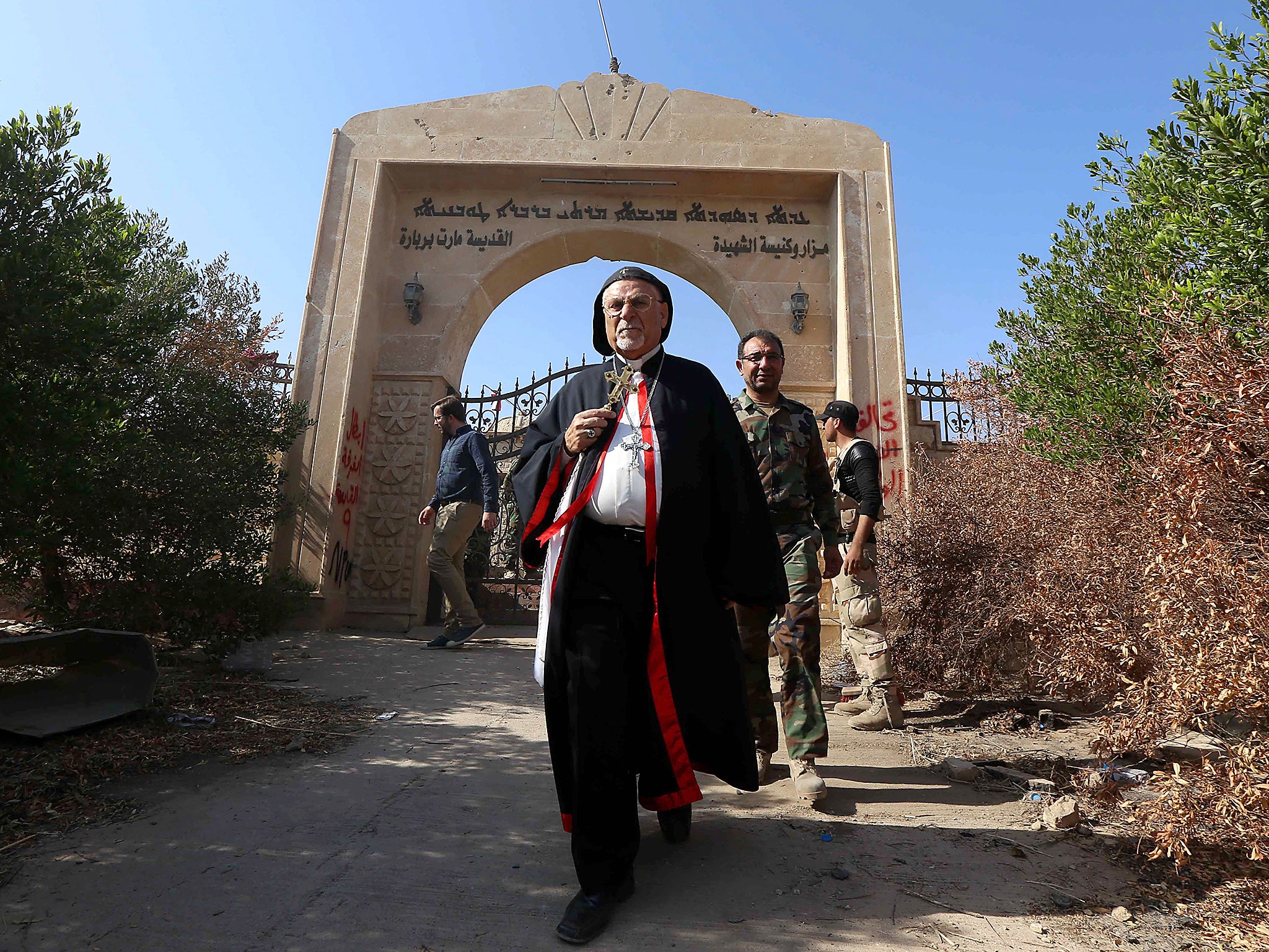 Archbishop Yohanna Petros Mouche of Mosul inspects the damage at the Saint Barbara church in Qaraqosh last month