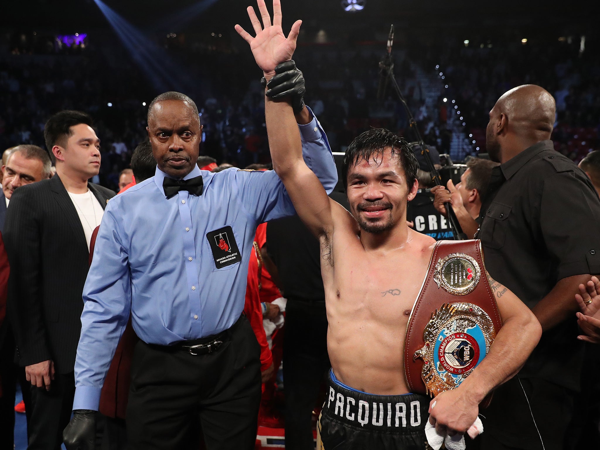 Pacquiao celebrates with his WBO welterweight belt after a successful return to the ring