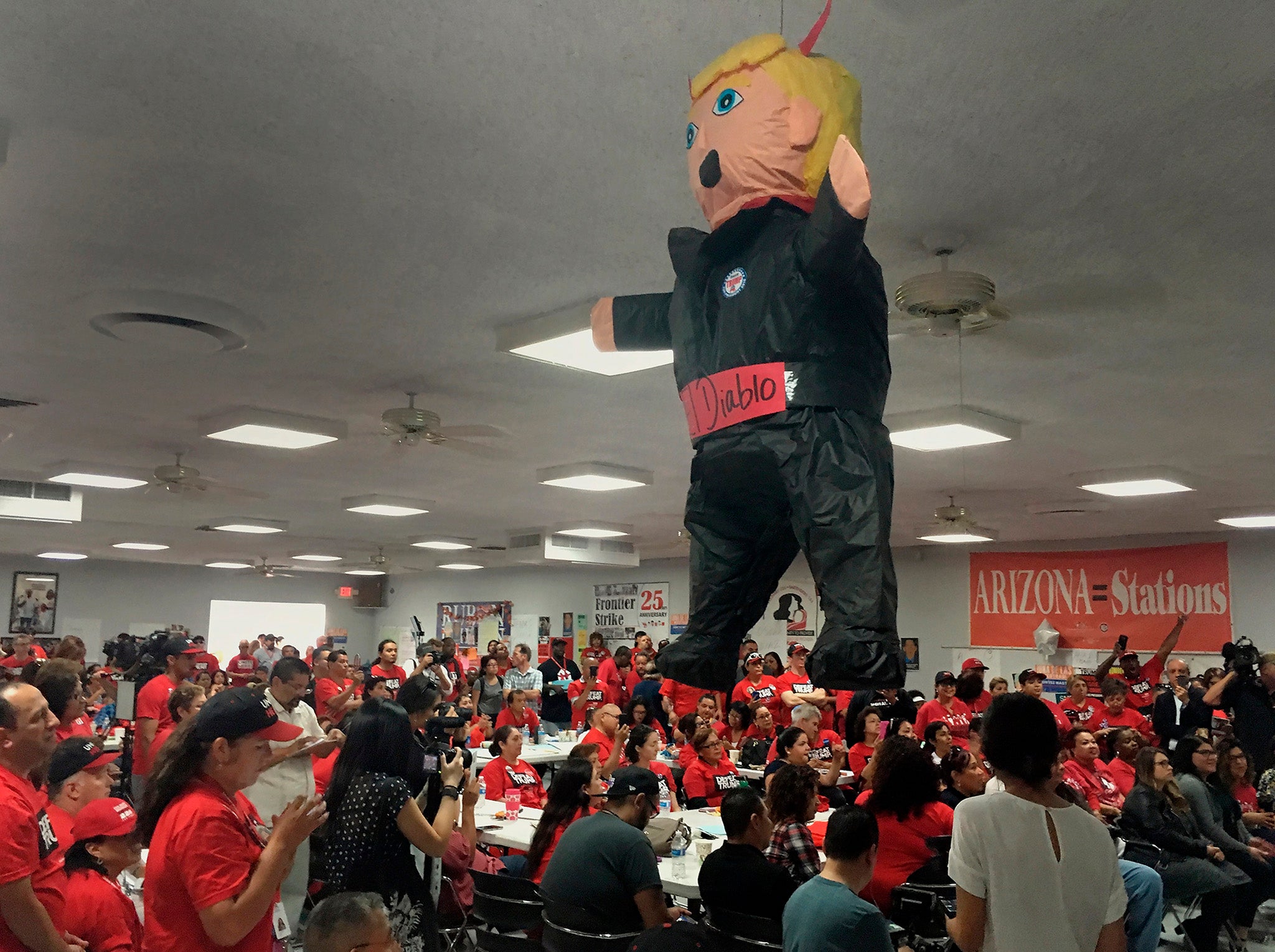 Members of the Culinary Workers Union Local 226, cheer during a rally under a Donald Trump pinata in Las Vegas