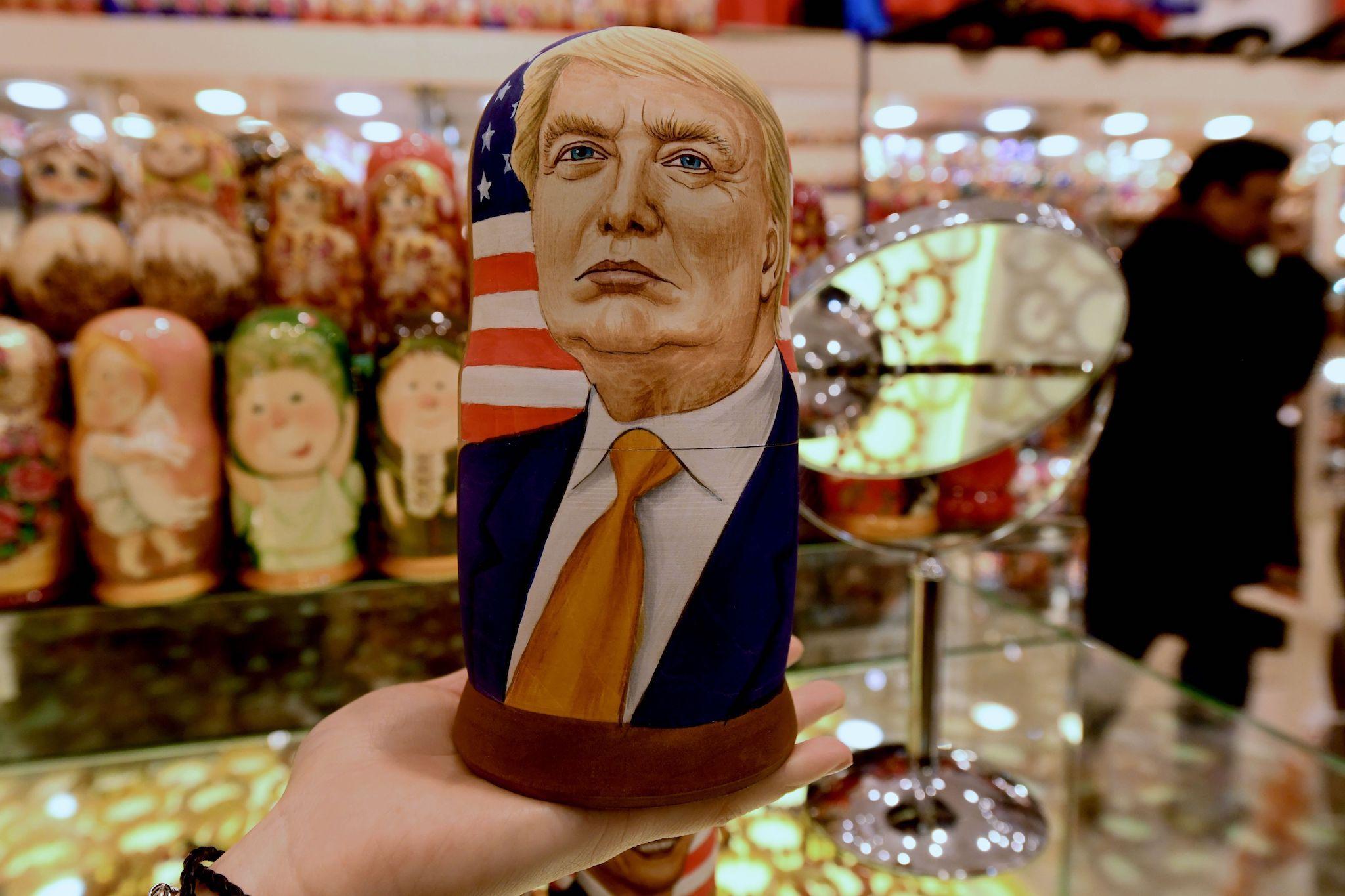 A woman examines a traditional Russian wooden nesting doll, a Matryoshka doll, depicting US Republican presidential nominee Donald Trump at a gift shop in central Moscow on November 8, 2016