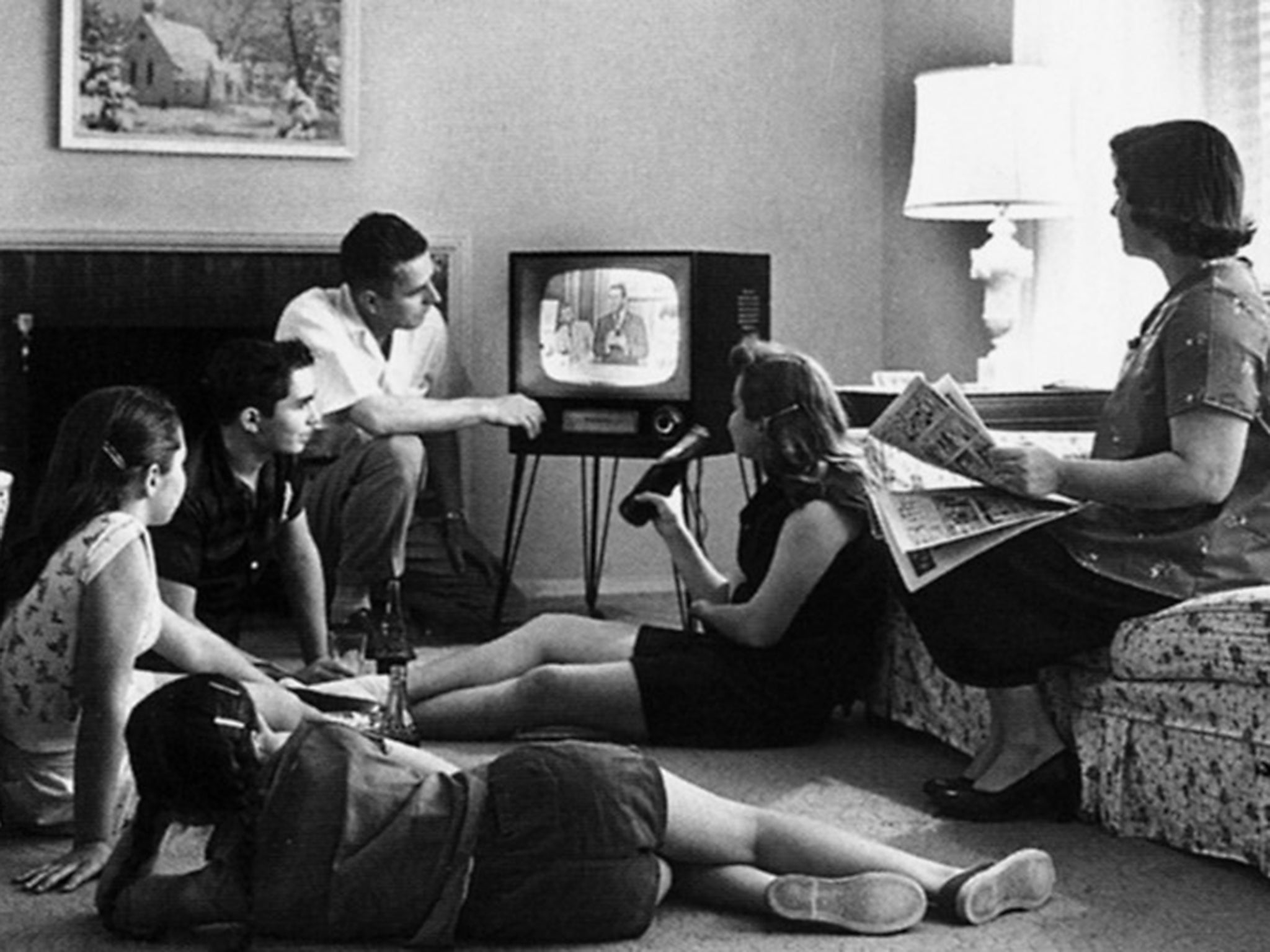 A family huddles around the television