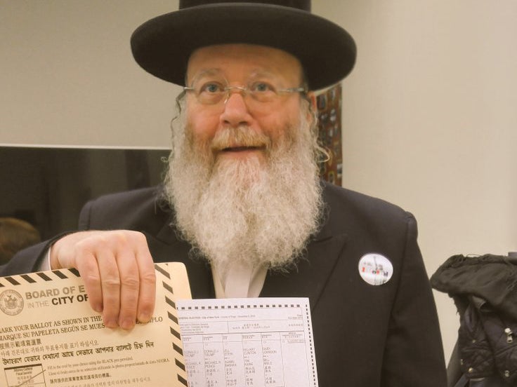 Yosef Rapaport holds up his ballot paper dedicated to US captain Humayun Khan