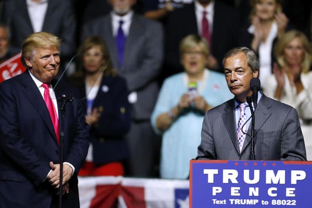 Donald Trump listens to Nigel Farage speak during a campaign rally at the Mississippi Coliseum in 2016