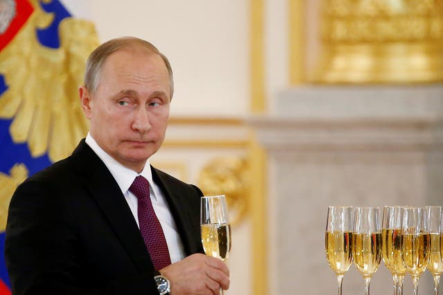 Russia's President Vladimir Putin holds a glass during a ceremony of receiving diplomatic credentials from foreign ambassadors at the Kremlin in Moscow, Russia