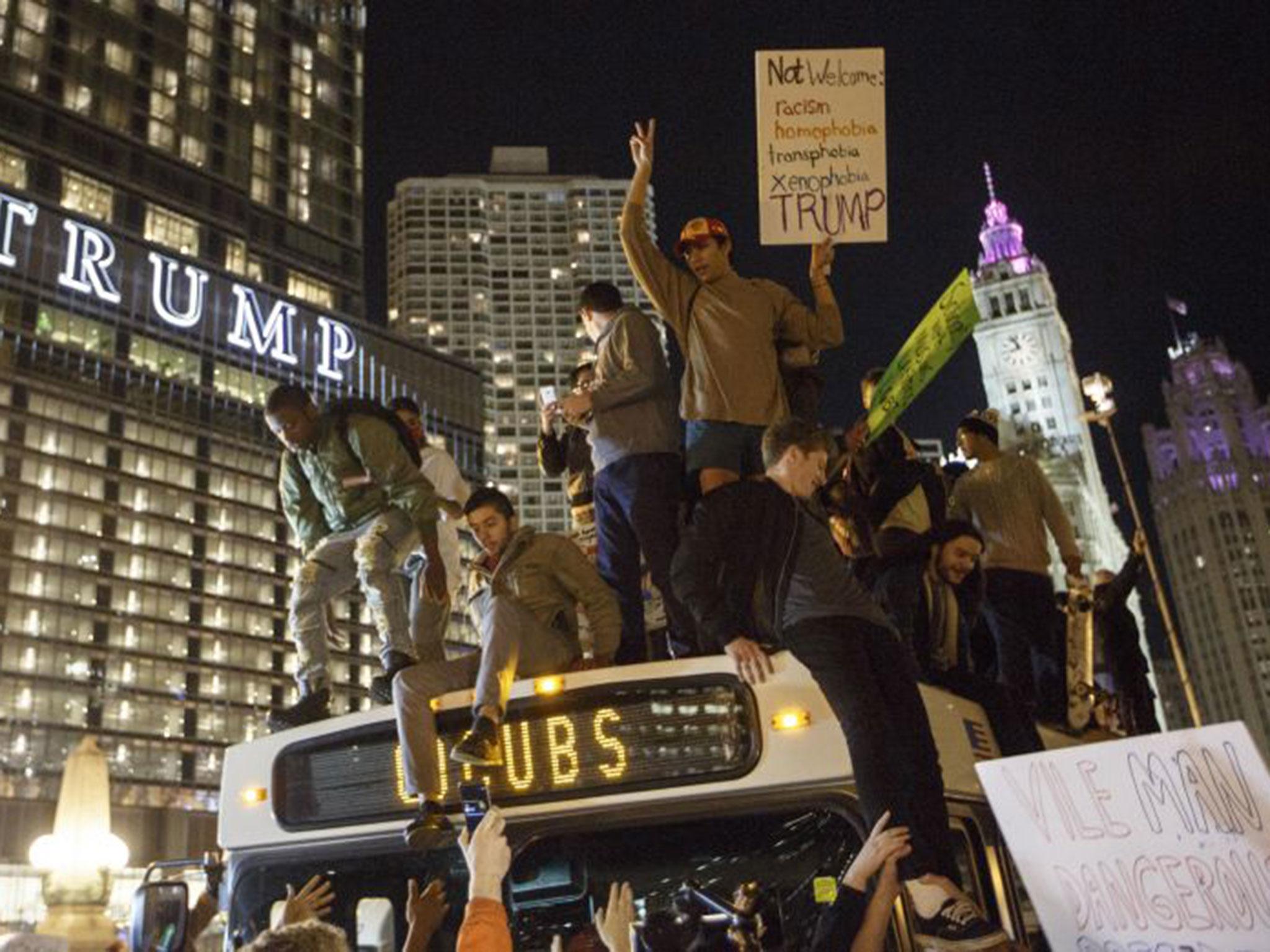 Demonstrators protest on top of a bus outside of the Trump Tower in Chicago, Illinois