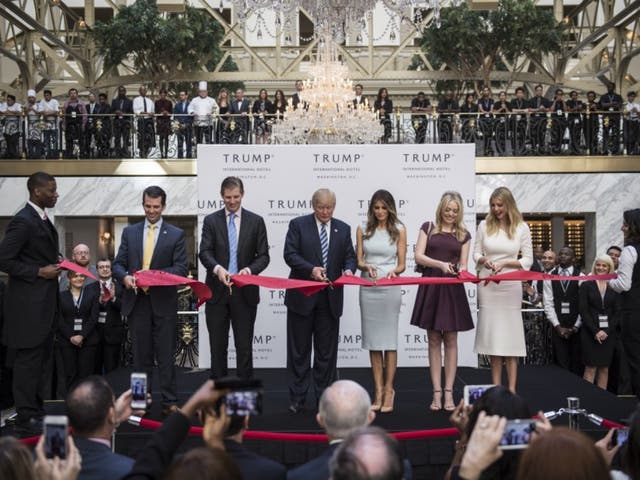 Donald Trump cuts a ribbon during the grand opening ceremony of the Trump International Hotel-Old Post Office in D.C. on October 26