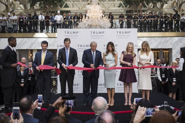 Donald Trump cuts a ribbon during the grand opening ceremony of the Trump International Hotel-Old Post Office in D.C. on October 26