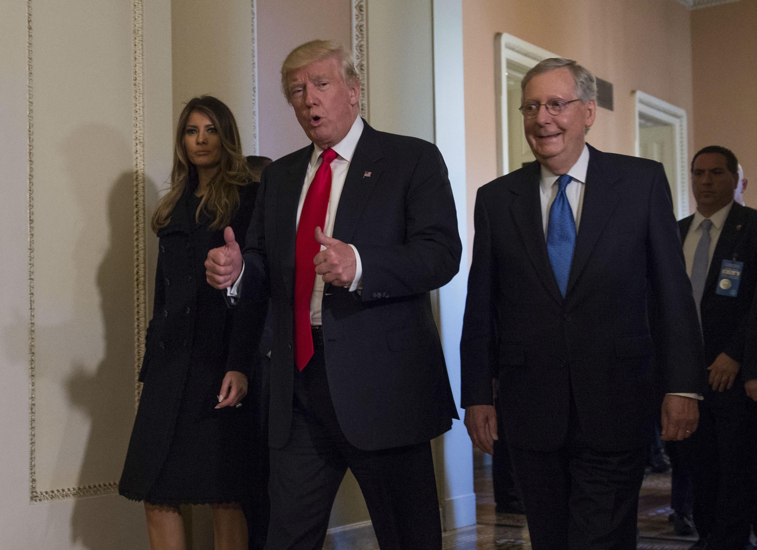 Donald Trump and his wife escorted by Mitch McConnell through the halls of Congress on Thursday