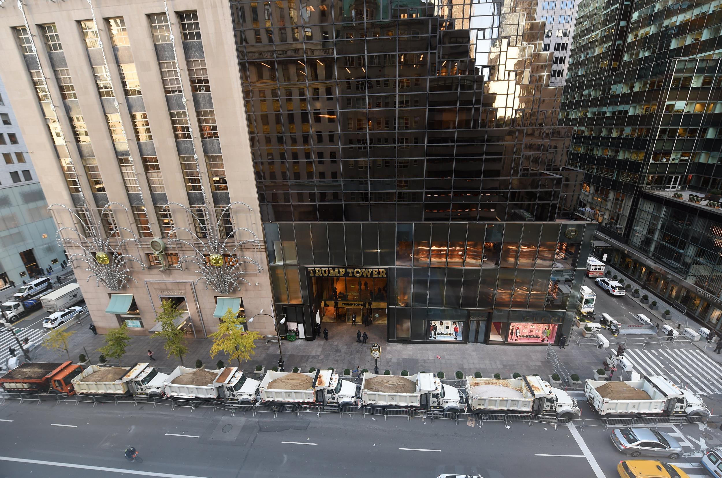 A protective barrier of Sanitation Department trucks are parked in front of Trump Tower Getty