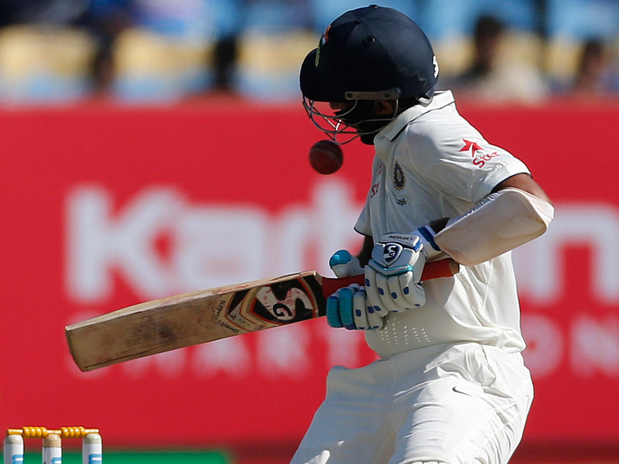 A ball hits the helmet of Pujara during his first Innings against England