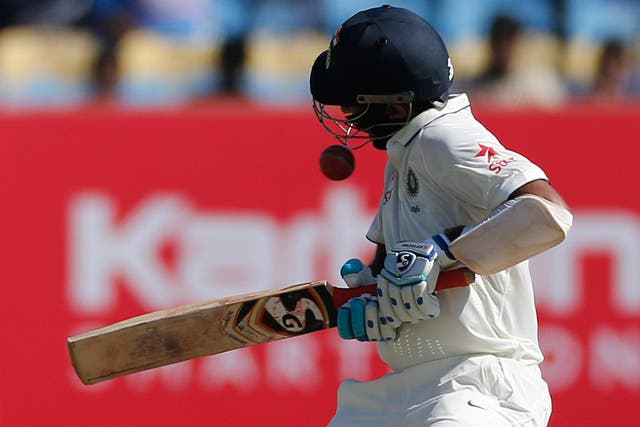 A ball hits the helmet of Indian batsman Cheteshwar Pujara during his first Innings against England