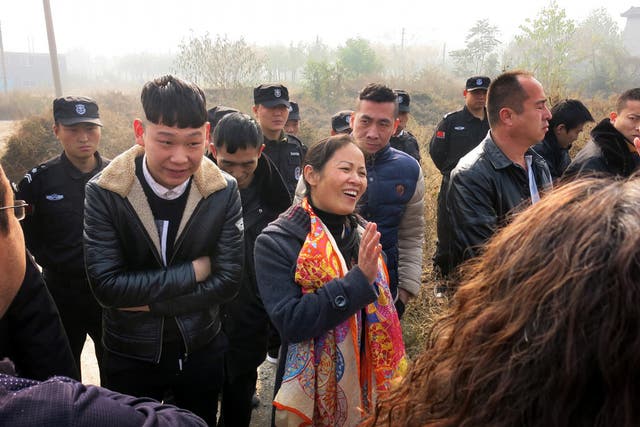 Liu Huizhen, at centre wearing an orange scarf, is surrounded by police and other unidentified men who prevented her from campaigning for the November 15 local elections on the outskirts of Beijing