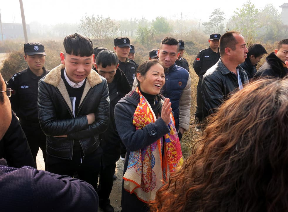 Liu Huizhen, at centre wearing an orange scarf, is surrounded by police and other unidentified men who prevented her from campaigning for the November 15 local elections on the outskirts of Beijing
