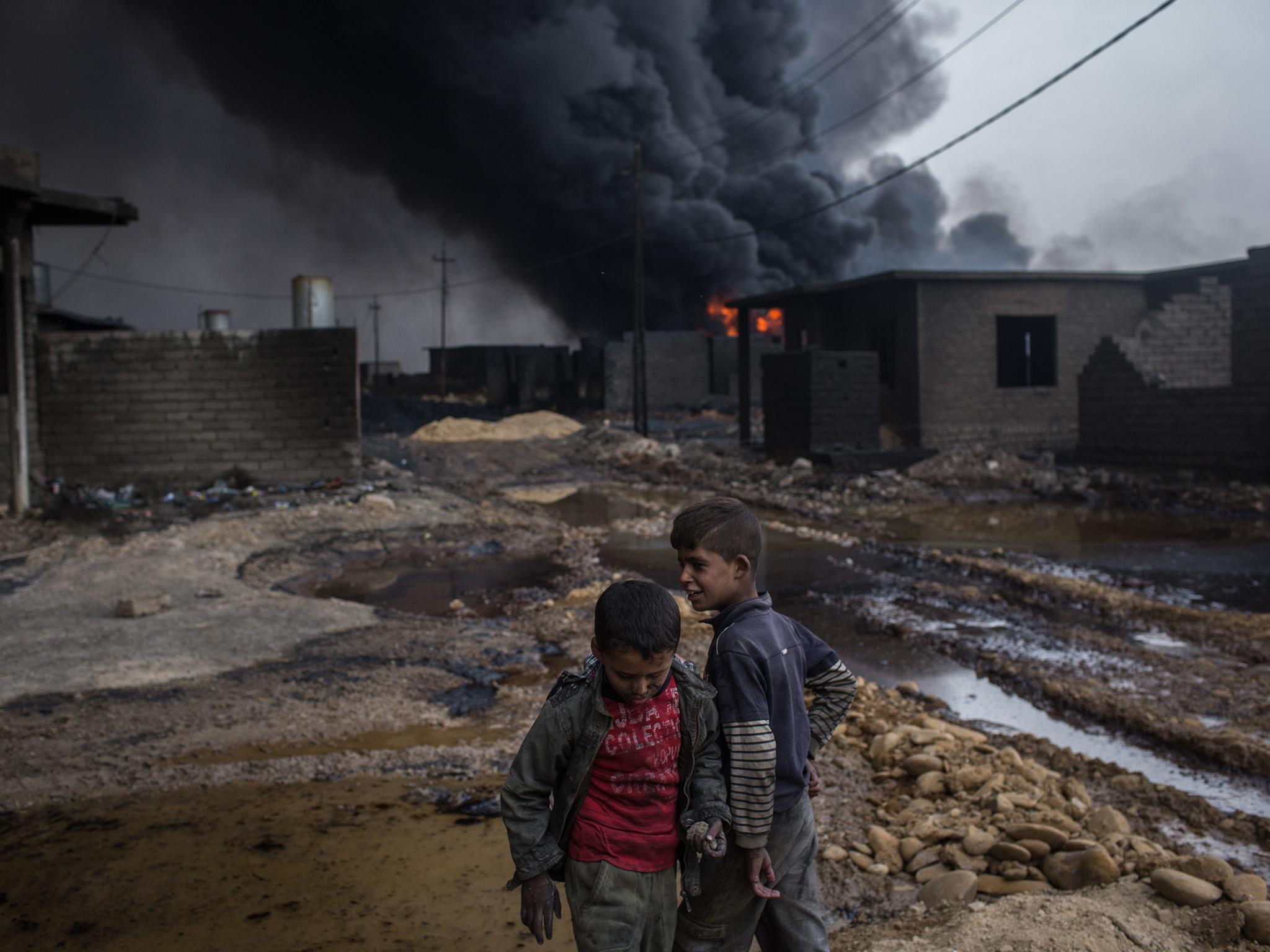 Two boys play in a street outside their home