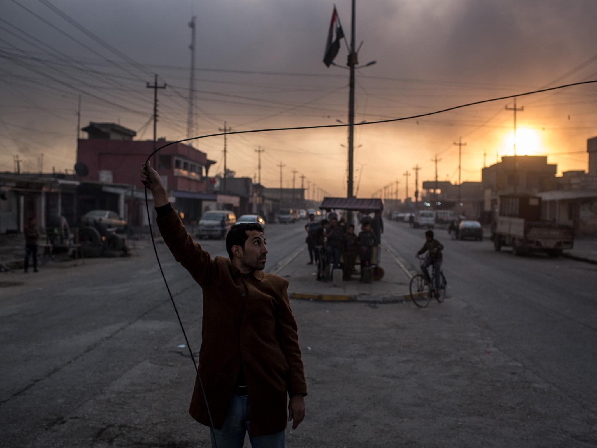 The sun barely barely breaks through the darkness, while people try to restore power to a street