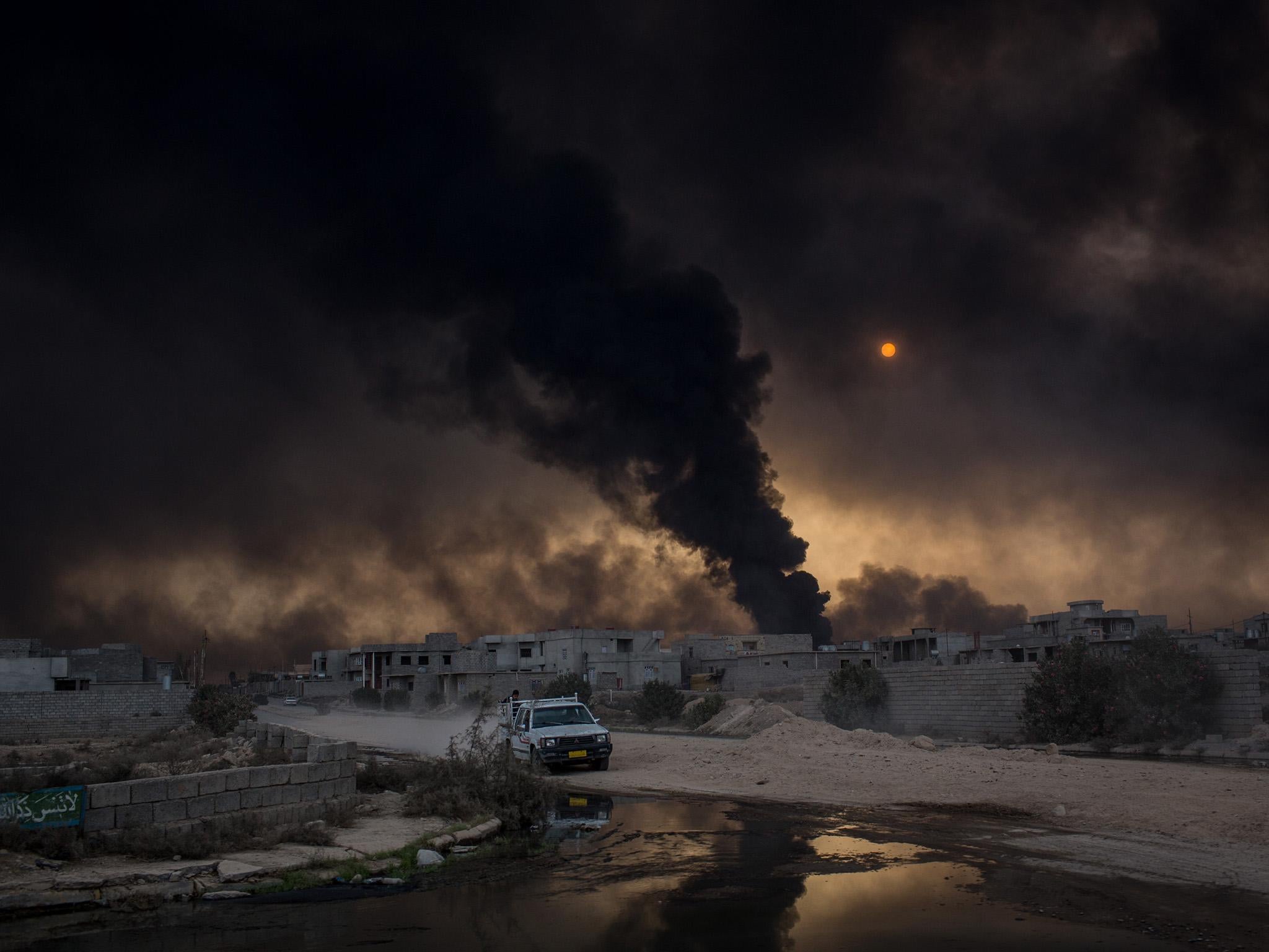 Heavy smoke from burning oil wells virtually blocks the distant sun
