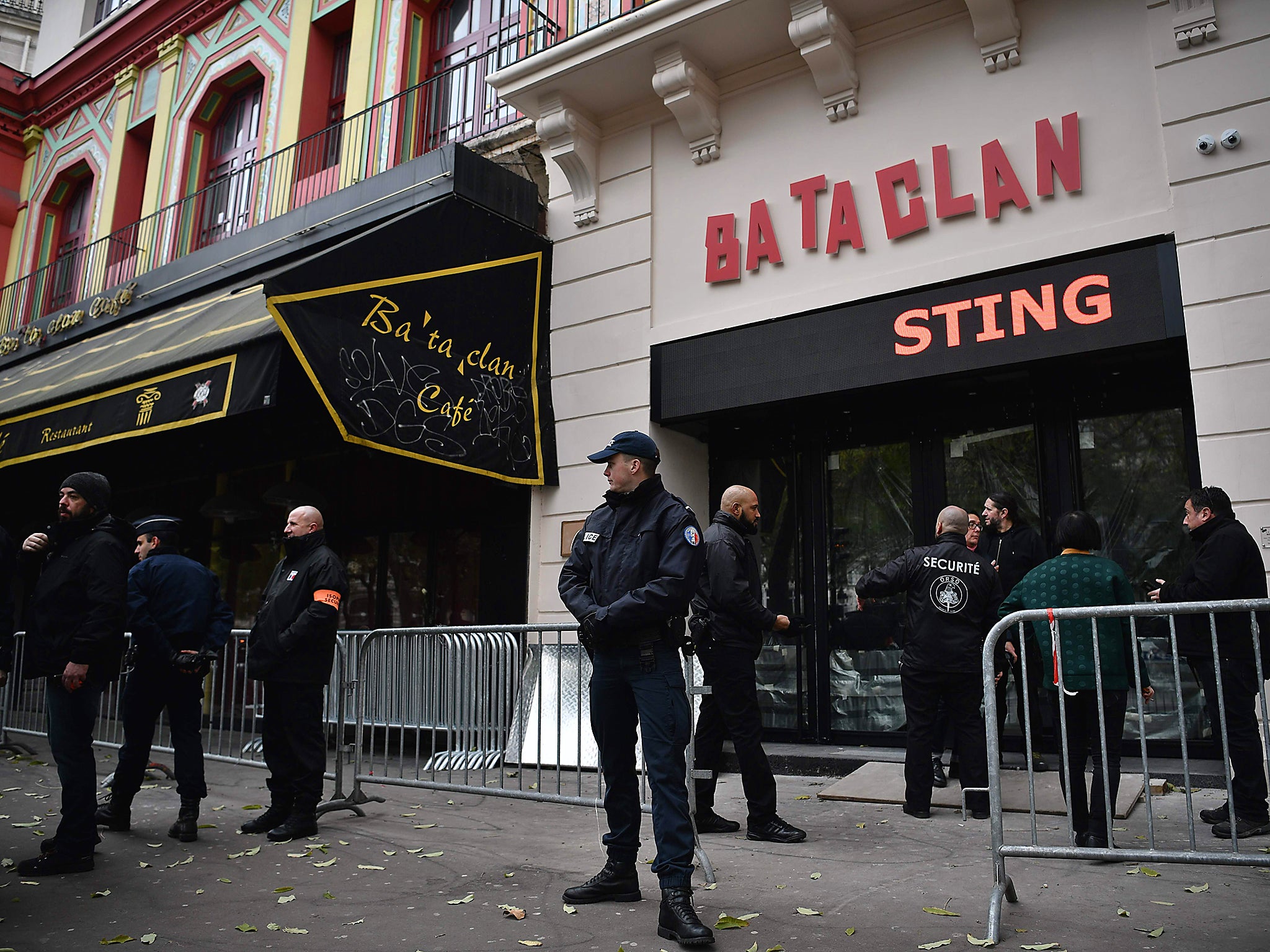 French policemen and security officers stand guard at the entrance of the Bataclan concert hall, a few hours before the reopening concert by British musician Sting to mark the first anniversary of the 13 November Paris attacks