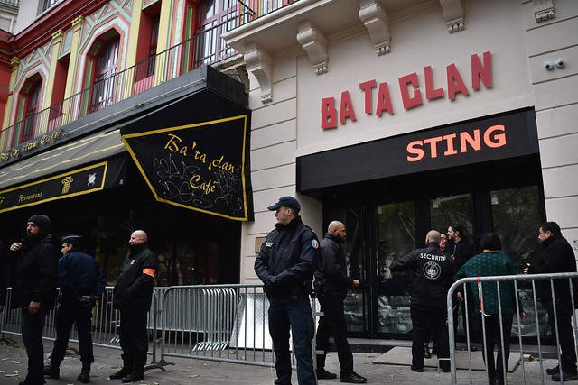 French policemen and security officers stand guard at the entrance of the Bataclan concert hall, a few hours before the reopening concert by British musician Sting to mark the first anniversary of the 13 November Paris attacks