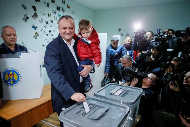 Moldova's Socialist Party presidential candidate Igor Dodon, accompanied by his son Nikolai, casts his vote at a polling station during a presidential election in Chisinau, Moldova, November 13, 2016