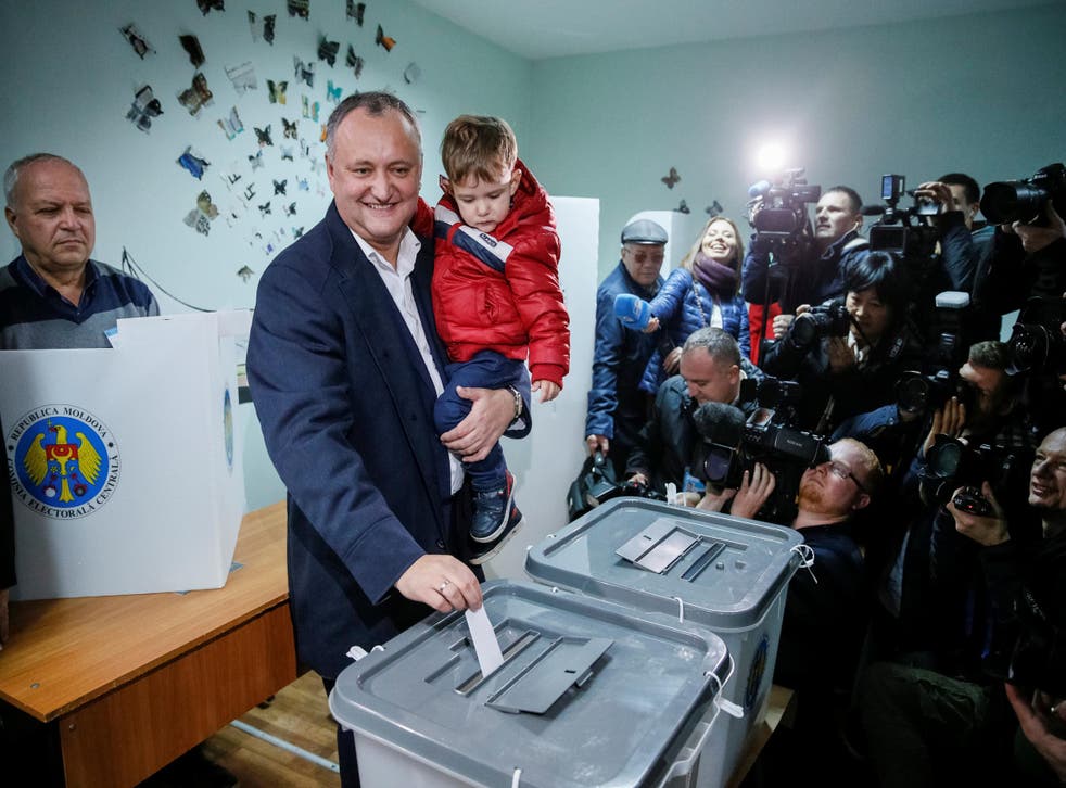 Moldova's Socialist Party presidential candidate Igor Dodon, accompanied by his son Nikolai, casts his vote at a polling station during a presidential election in Chisinau, Moldova, November 13, 2016