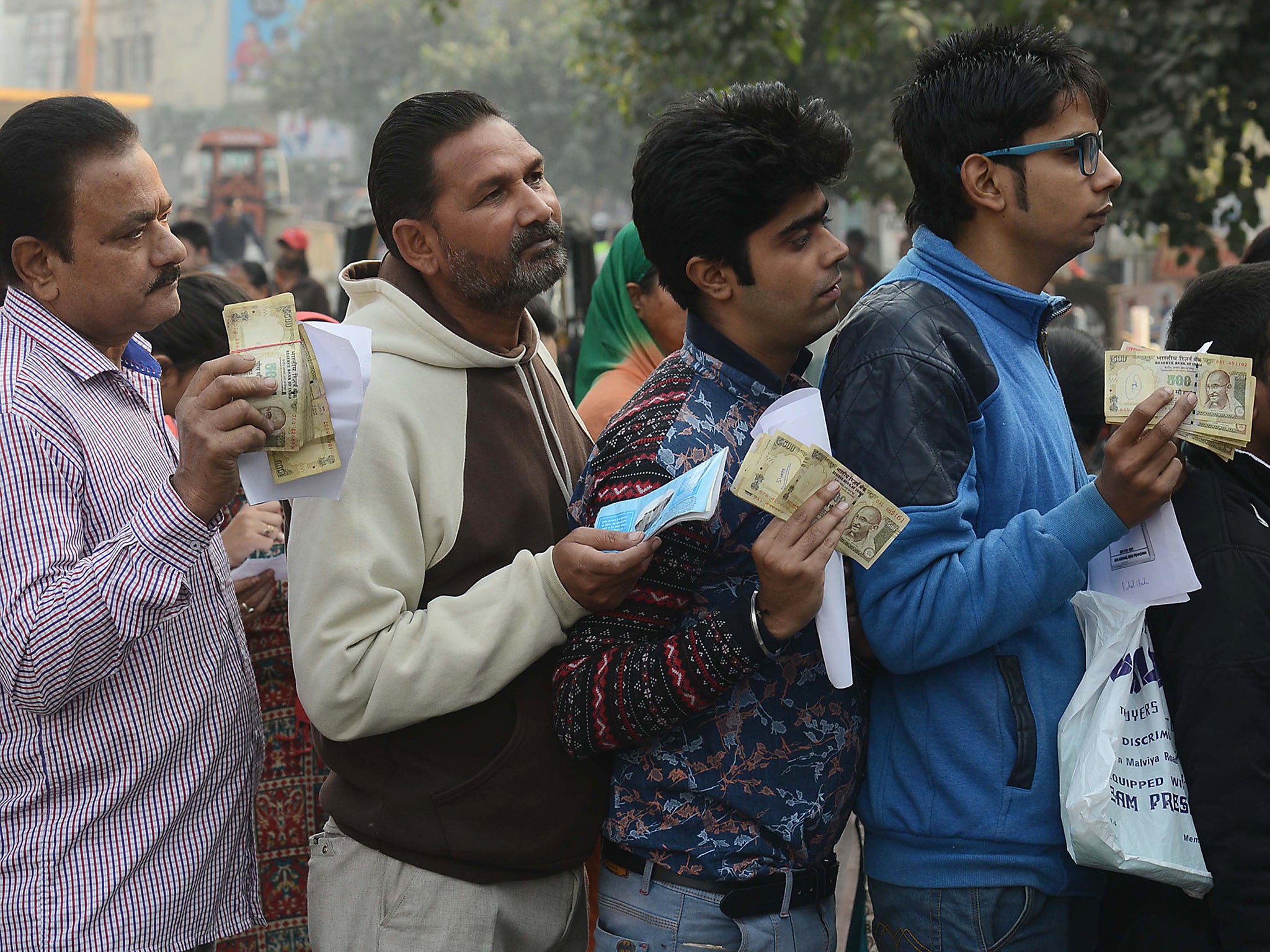 Indian people queue outside a bank as they wait to deposit and exchange 500 and 1000 rupee notes in Amritsar, India