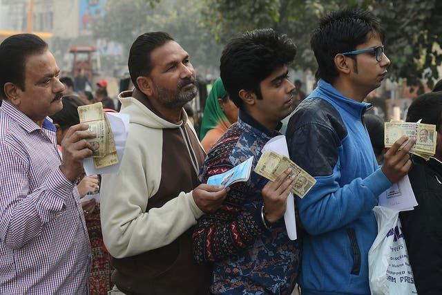 People queue outside a bank to deposit and exchange 500 and 1,000 rupee notes in Amritsar