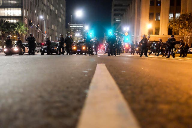 Police in riot gear stand guard outside City Hall during a protest against US President-elect Donald Trump in Los Angeles, California