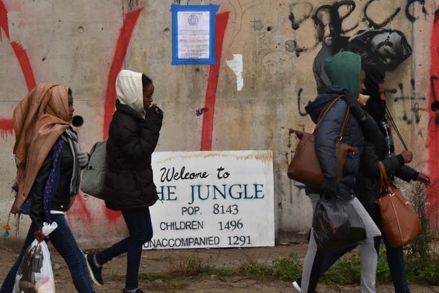Refugee girls towards an official meeting point set by French authorities as part of the full evacuation of the Calais "Jungle" camp, in Calais, northern France, on October 24, 2016